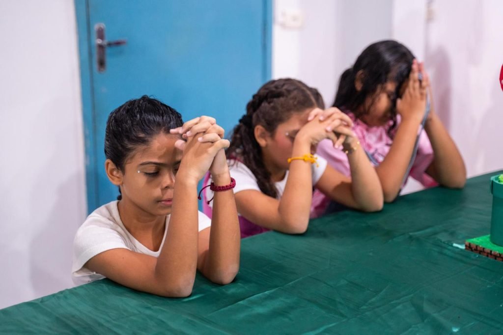 Children praying at the camp
