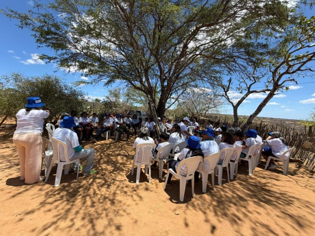 A Bible class gathers in the shade of a tree during the Children's Day visit.