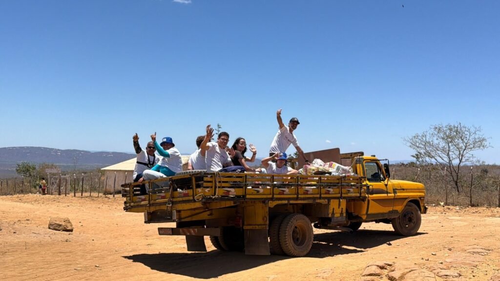 Church members wave from the back of the truck on the dirt road into Buíque.